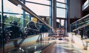 A low angle photo taken on the accessibility ramp in the stalls foyer looking out towards the large windows