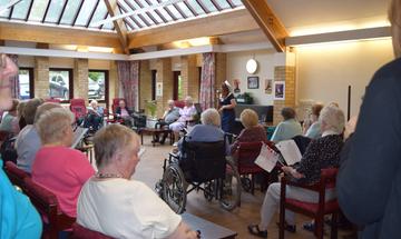 Anvil Arts practitioner working with a group of residents in a local care home in a project involving poetry, dance, music and reminiscence.