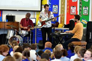 a band playing to school pupils