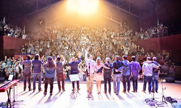 A photo taken from the back of The Anvil stage. Big Big Train are on stage, facing a sold out audience, who are cheering and giving a standing ovation