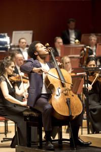 Sheku Kanneh-Mason playing the cello with the Philharmonia Orchestra, on stage at the Anvil at the 25th Anniversary Gala concert