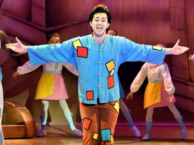 Aladdin with his hand held out to the side. He wears a blue and brown outfit