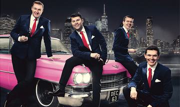 Four men in black suits with white shirts and red ties sat on a pink car with a black and white city skyline behind them