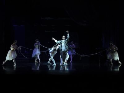 a male ballet dancer centre stage with female dancers surrounding him