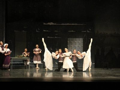 a large group of dancers gathered on stage, some dancing, some watching