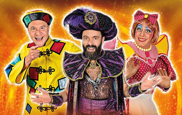 Chris Pizzey dressed as Wishee Washee, James Mackenzie as Abanazar, and Nic Gibney as Widow Twankey against a orange sparkly background