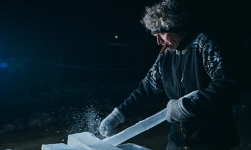 A man scraping and shaping a key for the ice xylophone