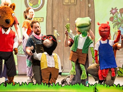 Puppets of Bear, Mole, Frog, and Squirrel on stage waving