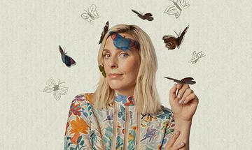 Sara Pascoe with shoulder-length blonde hair, wearing a floral-patterned top, surrounded by butterflies – some real and some illustrated