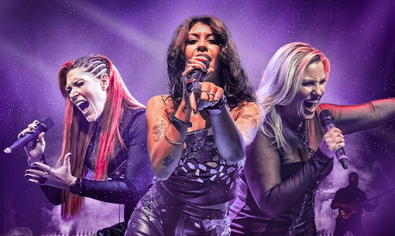 Three women passionately singing into microphones on a purple background