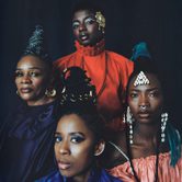 The band Les Amazones d’Afrique, four black women of various ages with striking make-up and hair, with bright tops