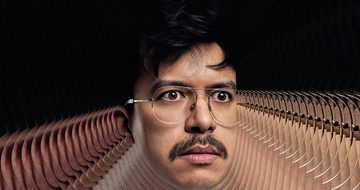 Phil Wang's head on a black background with a repeating pattern of his head coming out around him
