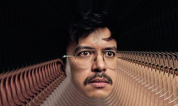 Phil Wang's head on a black background with a repeating pattern of his head coming out around him