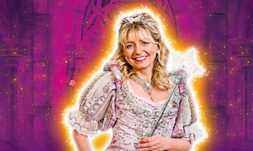 Sarah Jane Buckley, a white woman with blonde hair smiling at the camera wearing a pink and silver dress with a tiara and wand, against a purple sparkly background