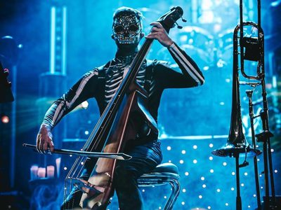 a man dressed as a skeleton playing the cello