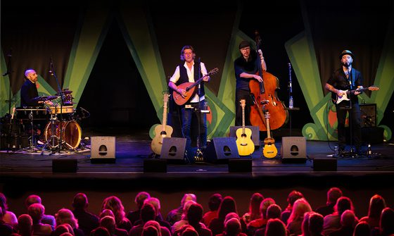 Steve Knightley and the The Winter Yards Band performing on stage in front of a large crowd of people