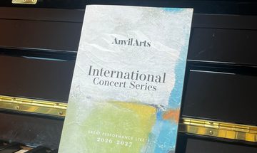 a what's on brochure resting on the keys of a piano