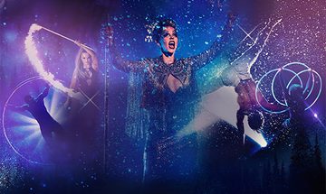Multiple performers on a dark blue and purple glittery background. From left to right, there is a performer in a large hoop, a woman waving a fire stick, a woman in the middle in a sparkly outfit who is singing, a male performer upside down in a handstand, and another performer is twirling multiple glowing hoops