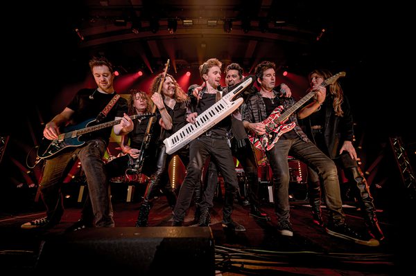 Seven musicians on a stage playing different instruments