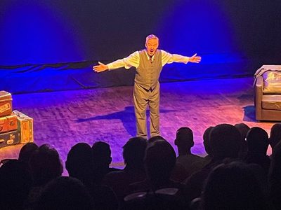 Charlie on stage with his mouth and arms wide open looking very excited