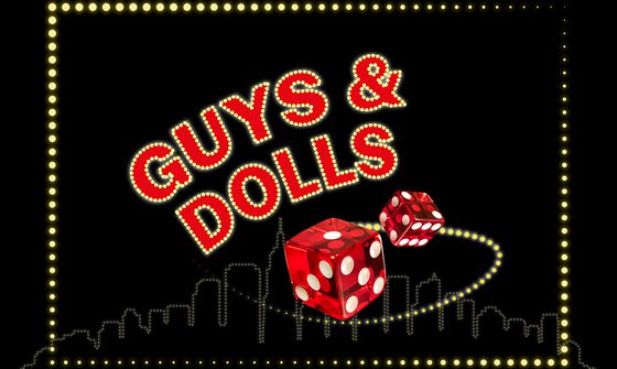 The words 'Guys & Dolls' in red on a black background surrounded by small golden lights. There is red dice also with a ring of lights around them. The image is bordered with lights and their is a faint skyline in the background also made out of lights
