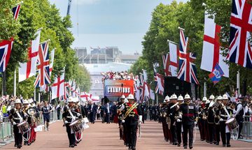 A marching band parade through London, leading the big red bus which is transporting the Lionesses