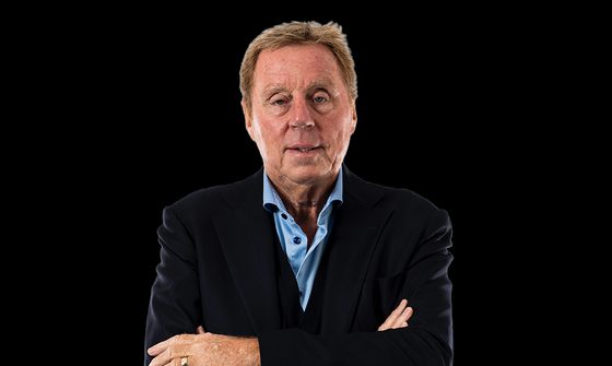 A photo of Harry Redknapp in a light blue shirt and dark blue jacket with his arms crossed on a black background