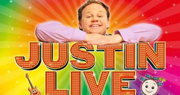 Justin Fletcher on a rainbow swirl background leaning on top of the words 'Justin Live' with a cartoon guitar and drum beneath