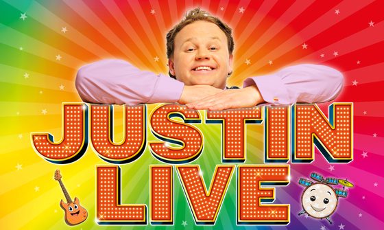 Justin Fletcher on a rainbow swirl background leaning on top of the words 'Justin Live' with a cartoon guitar and drum beneath