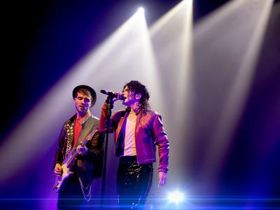 Michael Jackson tribute Ben Bowman singing into a microphone next to a guitarist