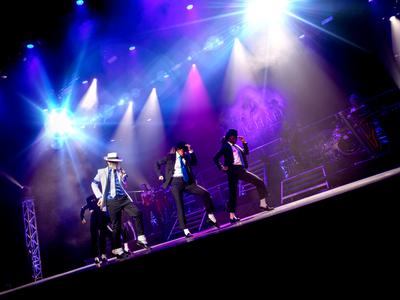 Michael Jackson tribute Ben Bowman doing the Smooth Criminal dance on stage with back-up dancers