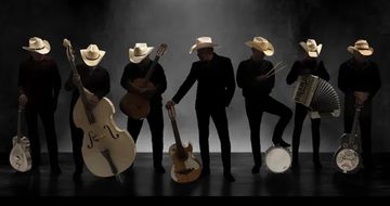 The silhouettes of seven men with cowboy hats and various instruments including guitars, drums, and an accordion