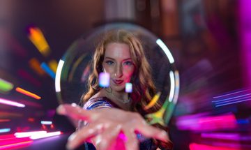 a woman with a giant bubble on her hand in front of her