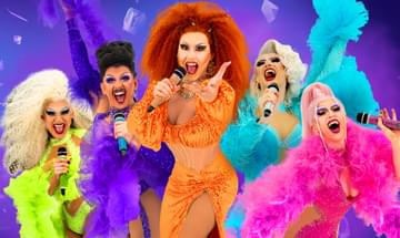 Five Drag Queens singing into microphones all wearing brightly coloured dresses