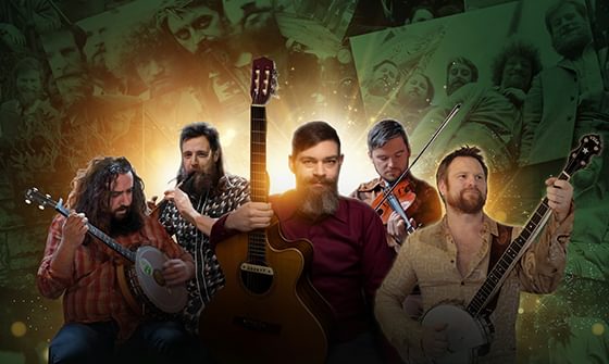 A band of five men with guitars, banjos, and a violin stand against a background of vintage photos, illuminated by a warm, glowing light