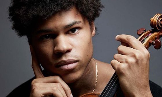 a black man holding a violin