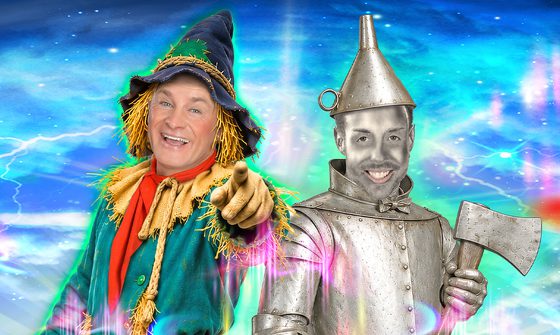 Bobby Davro dressed as a scarecrow and Stevi Ritchie dressed as the Tin Man standing together smiling. Bobby is pointing at the camera and Stevi is holding an axe