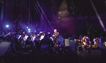 The Fulltone Orchestra performing on stage under purple lighting