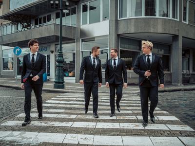 G4 crossing a road on a zebra crossing, all dressed in dark suits