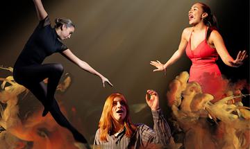 Three women on a grey background with orange smoke around them, the left one is brunette in a black leotard with hair in a tight bun dancing, the middle is ginger in a grey striped shirt with her left arm up looking and mouth open, the right one is dark haired in a red dress with both arms out to the side and she is singing