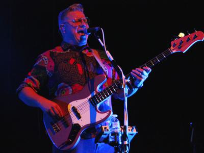 A man playing a guitar and singing into a microphone