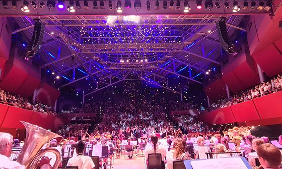 A photo from the back of The Anvil stage looking over lots of students playing instruments, dancing, and having confetti fall from the ceiling