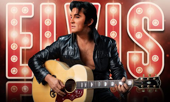 Ben Portsmouth, an Elvis impersonator, dressed as Elvis in front of bright red lights reading 'Elvis' and holding a guitar