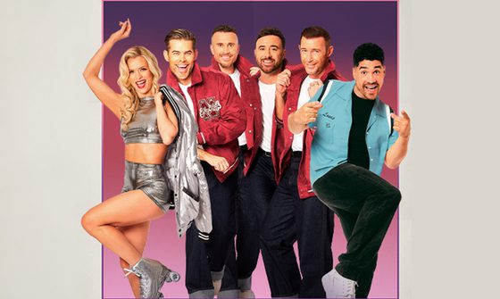 Nadiya Bychkova in a silver top, shorts, roller skates, and jacket that she's holding over her shoulder. To the right of her are The Overtones in white t-shirts with red letterman jackets over the top and black trousers. And on the very end next to them is Louis Smith, in a bright blue bowling shirt with black trousers and white shoes. Everyone is smiling and posing. They're in a box with a purple gradient and a beige background surrounding them.