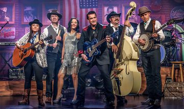 Six people holding various instruments like a guitar, drum sticks, banjo, and double bass. The background is purple with Americana decorations like and American flag, and black and white photos of country singers