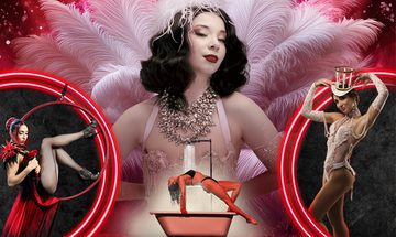 A large image of a woman with dark curled hair in a sparkly skin tone outfit with a large necklace surrounded by long white feathers stands over a smaller image of a woman in a black bikini stretched over a bath tub being covered in water from the shower above her. There is also two red rings either side with an image of a woman in a red hoop, wearing a black and red dress on the left and a woman in a sparkly white body suit with lace gloves, pearls, and a top hat that looks like just the frame work to the right