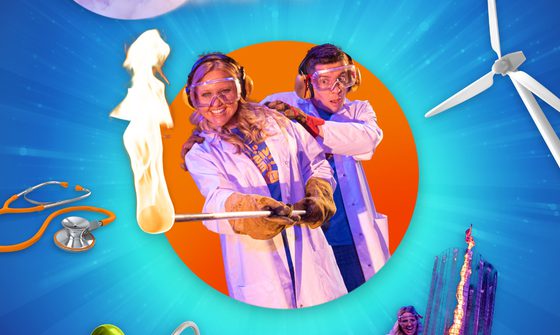 A male and female scientist, both in lab coats, the female scientist holds out a stick with fire on the end. They're both pictured within an orange circle on a blue background