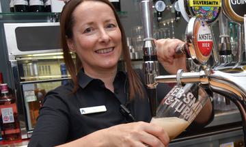 A member of the Front of House team at The Anvil pours a pint of beer
