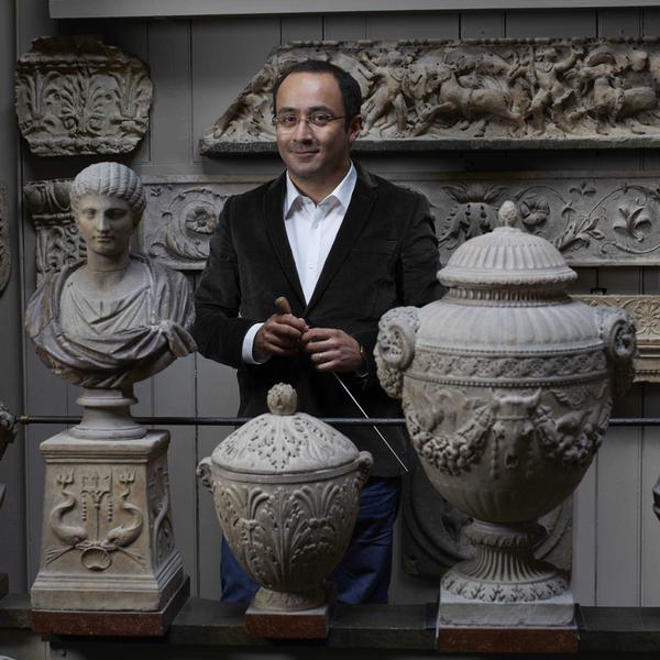 Riccardo Minasi stood in a museum next to artefacts